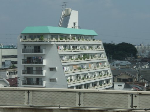 On the bus. Pass multi-floor housing near Tokyo.