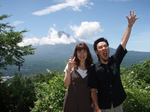 Hiking friends celebrate seeing Mount Fuji peak from Mount Tenjo at Kawaguchiko Japan.