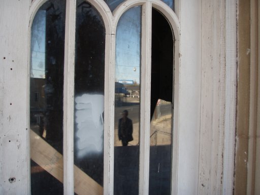 The reflection of a visitor appears in the door glass of the Baker Hotel.