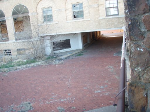 A empty driveway leads under the hotel to the guest drop-off. 