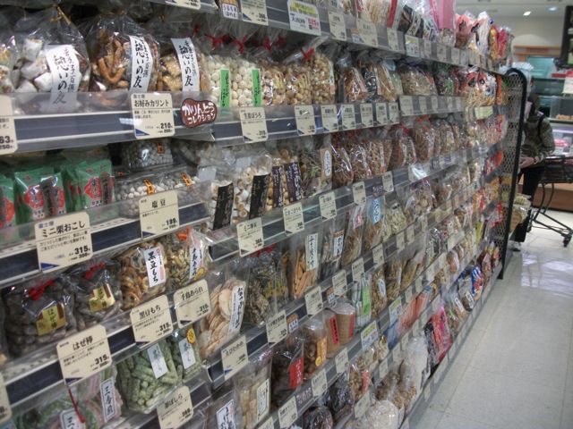 The snacks aisle of a Japanese grocery store offers spicy, salty and sweet treats tailored to Japanese tastes. Others can easily adapt to the new flavors. This photo was taken in a 100-yen discount store with a full grocery department in the basement. Snacks are available at grocery stores, convenience stores and supermarkets.