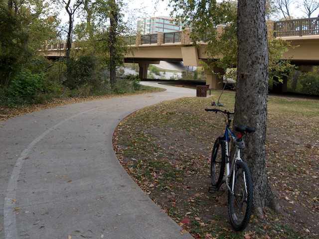 The park trail winds under a connector street. The connector street ties together feeders streets with office buildings and cuts through the park.