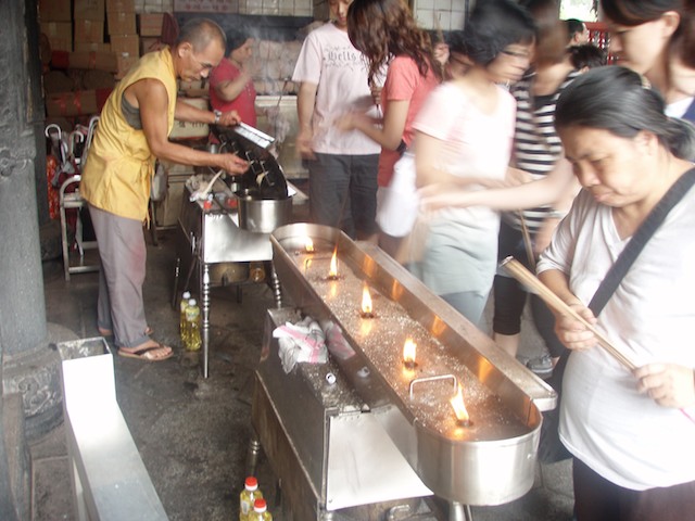 Worshippers burn incense at Lungshan Temple in Taipei, Taiwan. The incense represents prayers to idols and ancestors.
