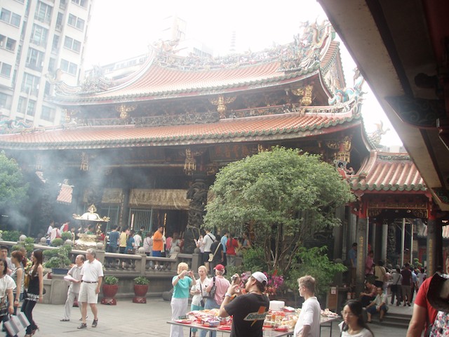 Lungshan Temple in Taipei Taiwan is surrounded by modern apartment buildings, creating a mixture of old and new.