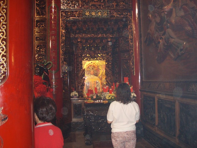 Worshipper kneels before an idol in the temple for Matsu. It is located in the Dajia District of Taichung, Taiwan