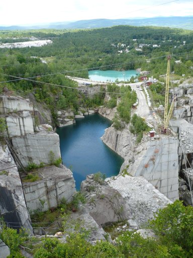 Lakes mark the original and current granite cutting work sites at the E. L. Smith Quarry in Barre, Vermont, USA. The farther lake shows the location of the origin quarry. It is more than 350 feet deep and filled with water from rain fall and melting snow. The closer lake is in part of the site no longer quarried.