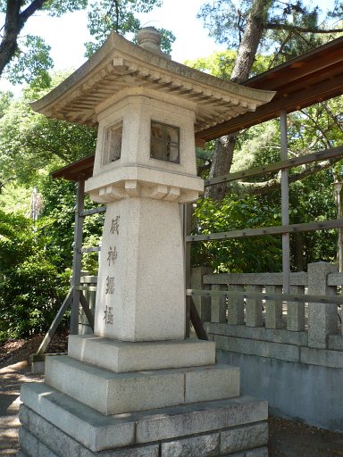 A sqaure stone lantern sits atop a three-level square pedestal .
