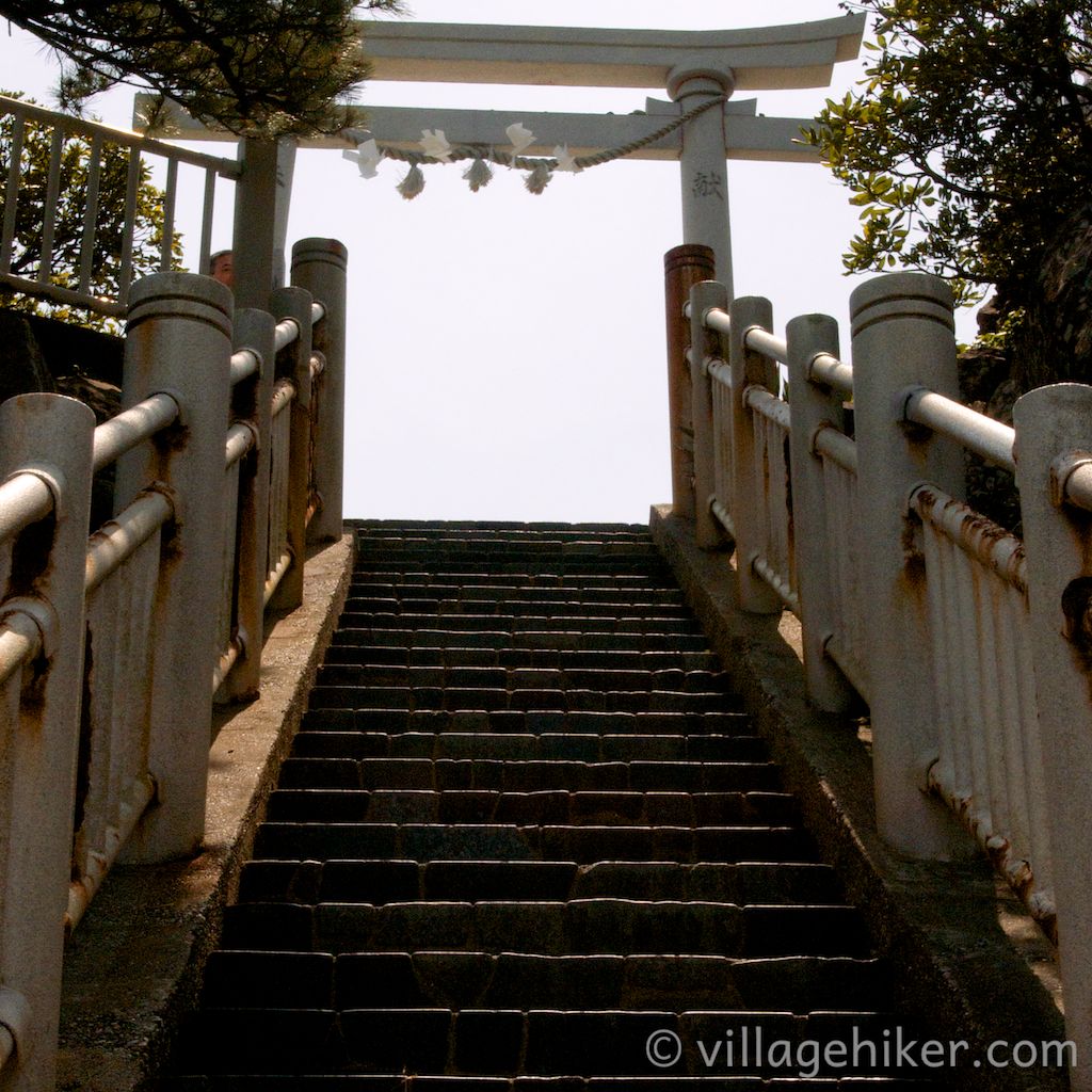 Steps lead up and under the torii—Shinto shrine gate—of Watatsumi Shrine.