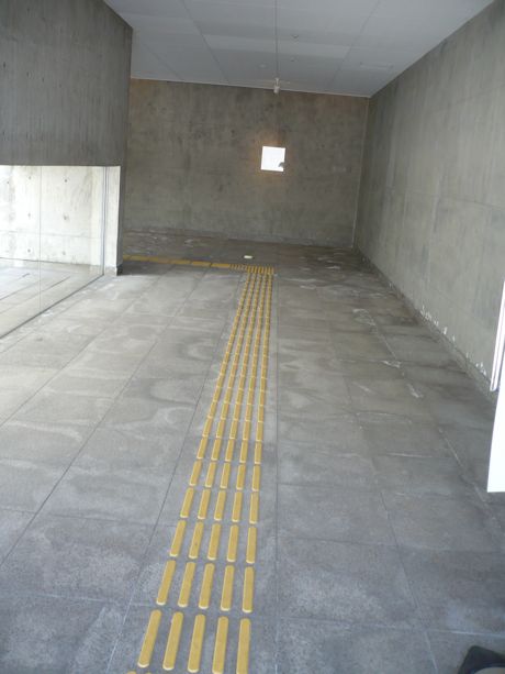 Straight bands of yellow tactile tiles mark a safe walking path without obstacles for the blind and the visually impaired in Japan
