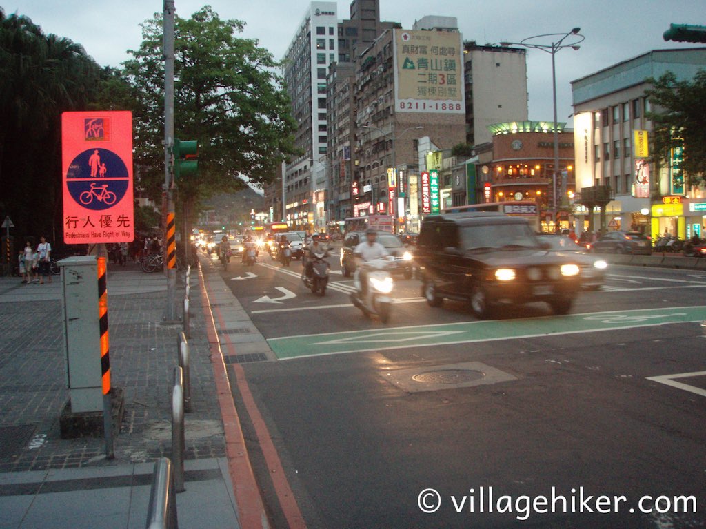 Scooters and car in evening in Taipei